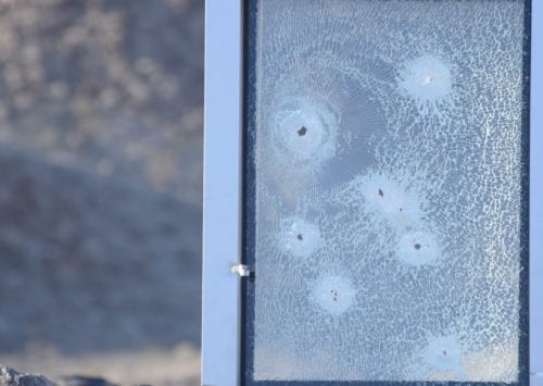 bullet holes through glass window outside