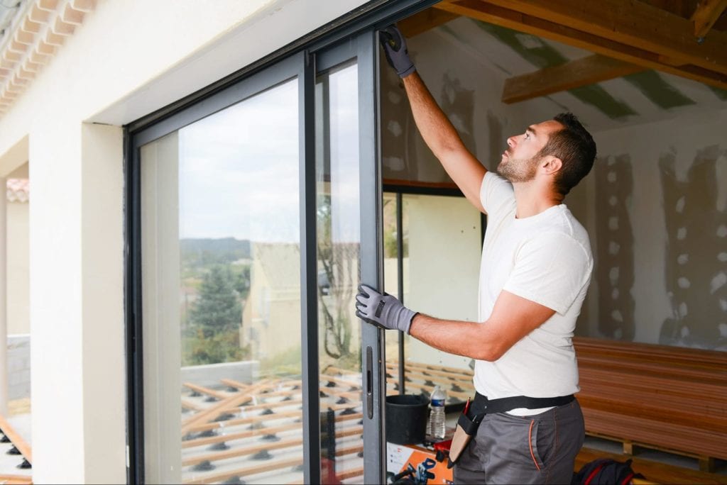 man installing sliding glass doors