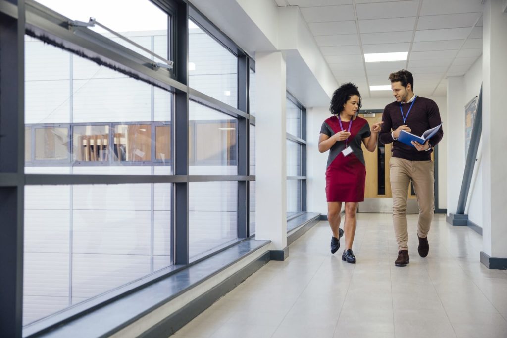 man and woman walking through office building