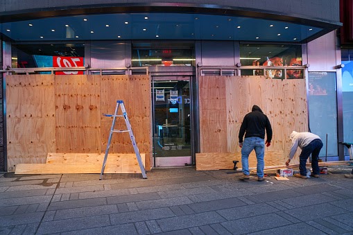 Carpenters board up a storefront in Times Square in anticipation of unrest related to to the upcoming presidential election.