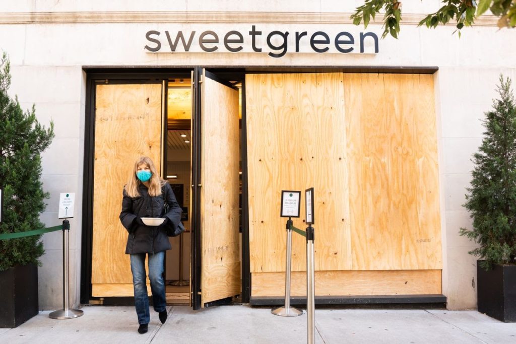 boarded up doors beneath "sweetgreen" sign