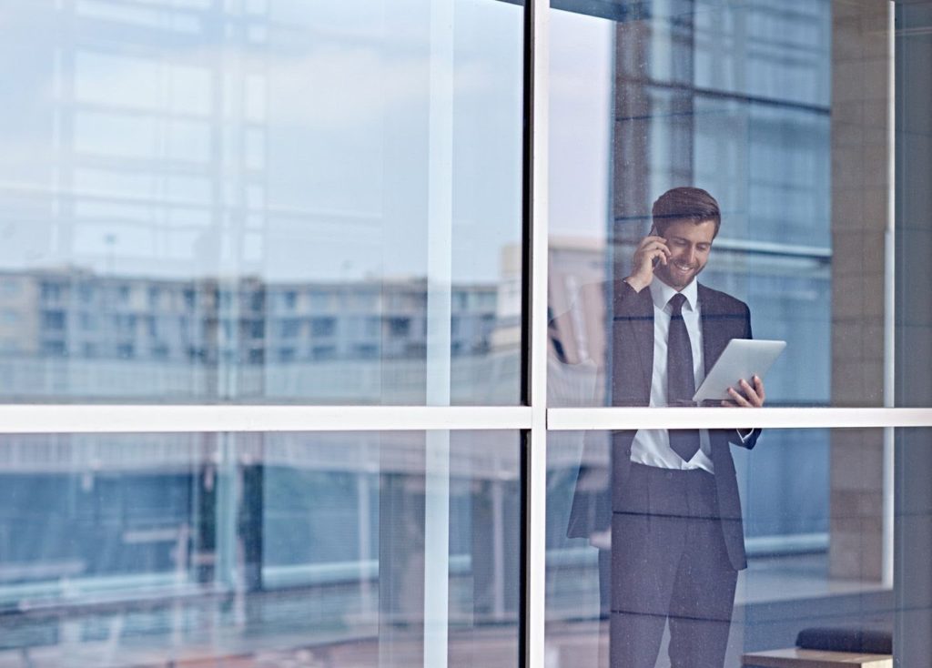 business man standing in front of windows