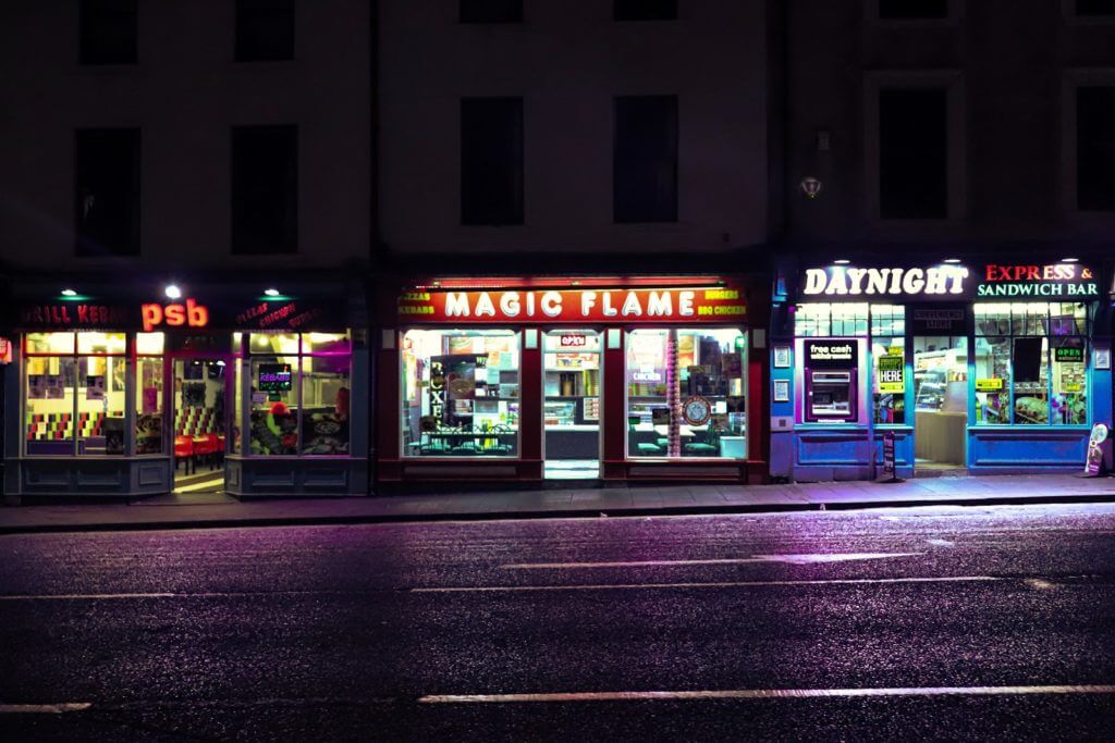 glass storeronts along street at night