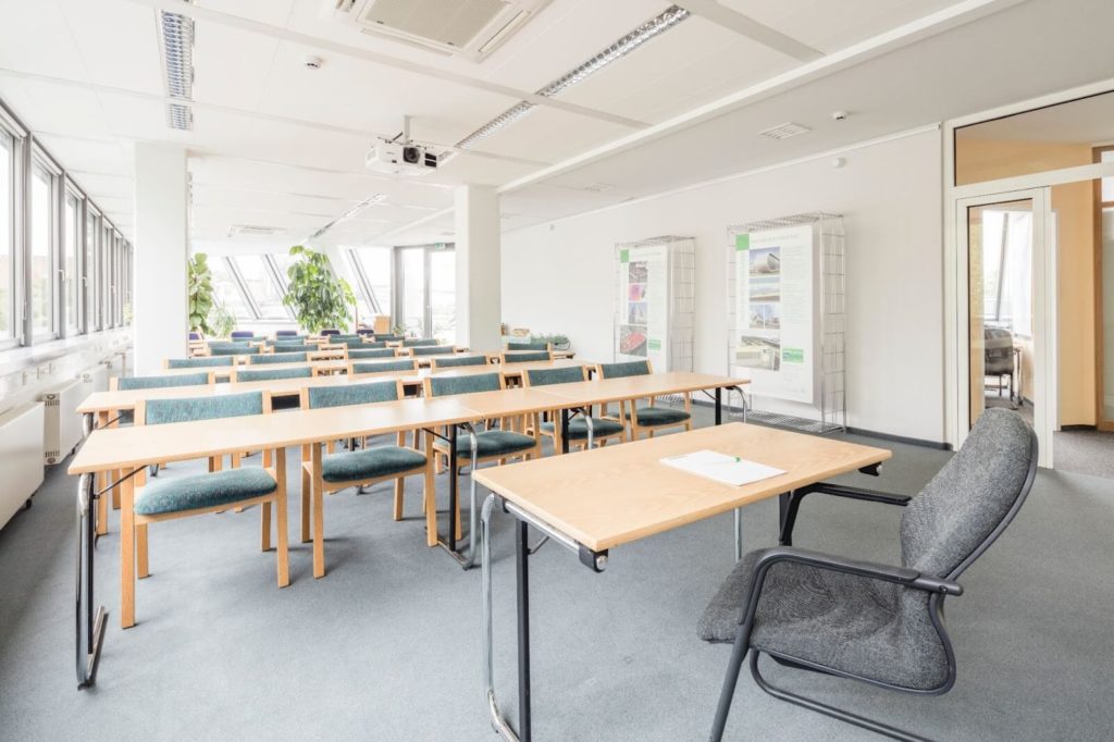 row of desks in building with lots if windows